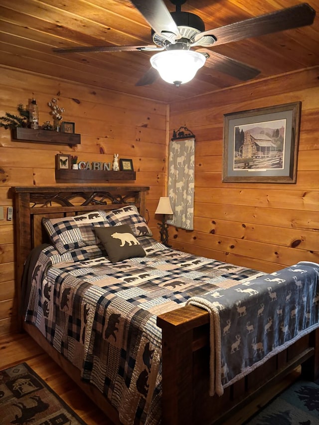 bedroom with wood ceiling, wood finished floors, wooden walls, and ceiling fan