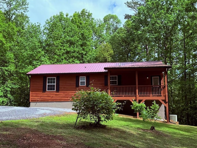chalet / cabin featuring central AC, a front yard, metal roof, and a porch