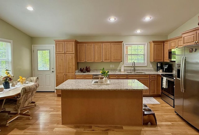 kitchen featuring stainless steel appliances, vaulted ceiling, a sink, recessed lighting, and a center island with sink