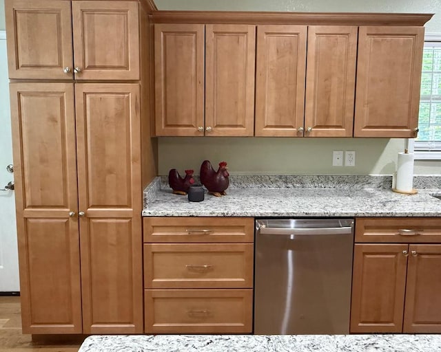 kitchen featuring dishwasher, light stone countertops, and brown cabinetry