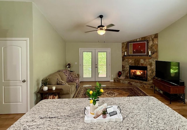 living room with vaulted ceiling, a ceiling fan, wood finished floors, french doors, and a fireplace