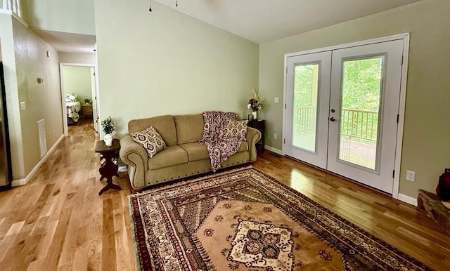 living area featuring wood finished floors, french doors, and baseboards