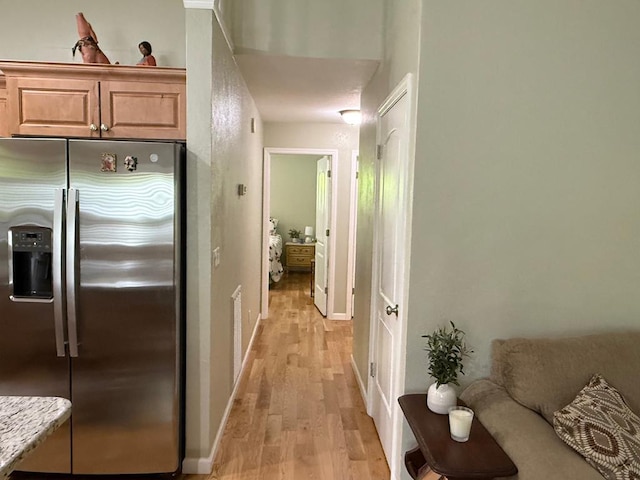 corridor featuring light wood-style floors and baseboards