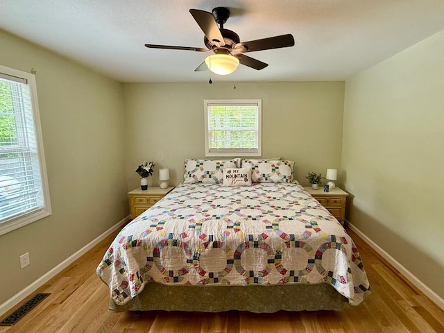 bedroom featuring wood finished floors, baseboards, and a ceiling fan