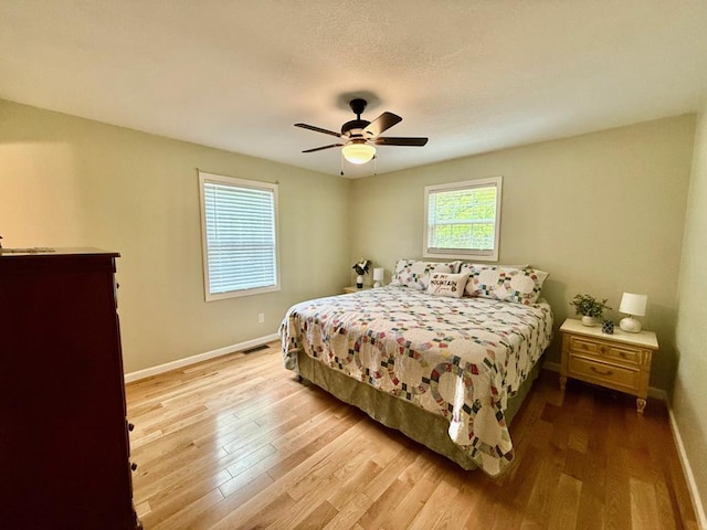bedroom with baseboards, wood finished floors, and a ceiling fan