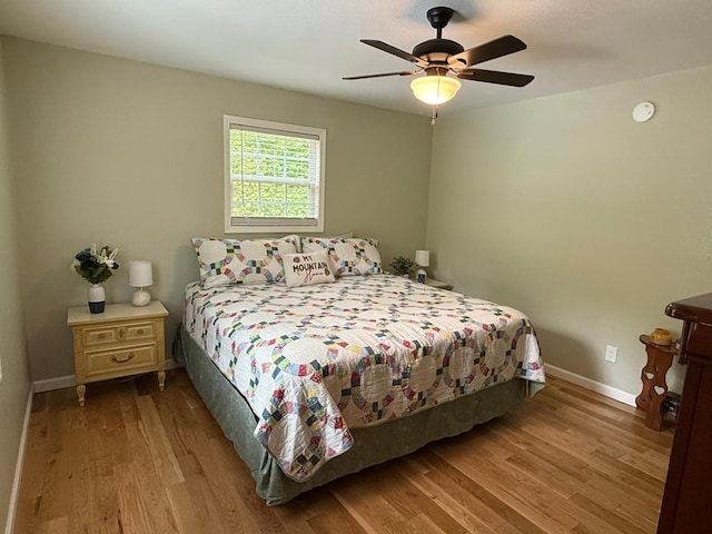 bedroom with wood finished floors, baseboards, and a ceiling fan