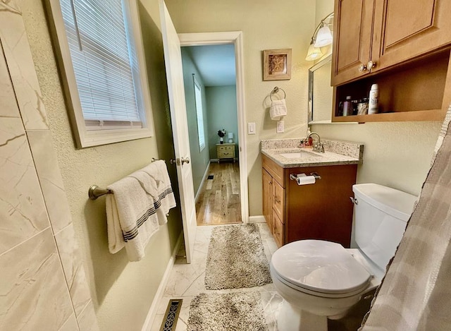 bathroom with toilet, vanity, baseboards, and french doors