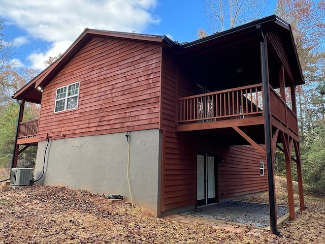 view of side of home with central air condition unit and a wooden deck