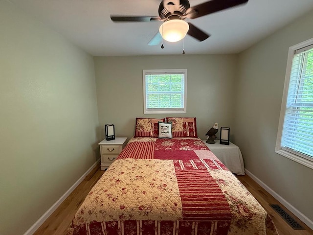 bedroom featuring wood finished floors, baseboards, and ceiling fan