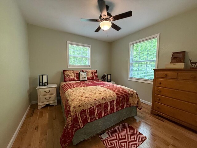bedroom featuring light wood-style floors, baseboards, and ceiling fan
