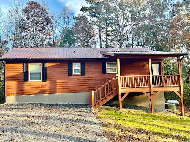 view of front of house featuring metal roof and stairway