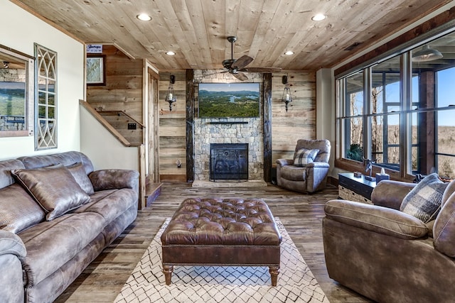 living room featuring wooden walls, plenty of natural light, wooden ceiling, and a fireplace