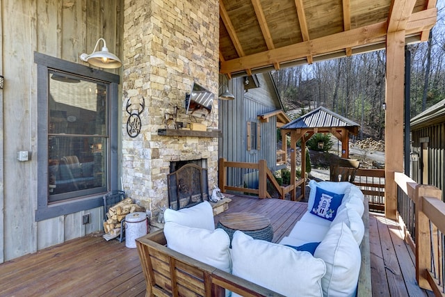 wooden terrace with a gazebo and an outdoor living space with a fireplace