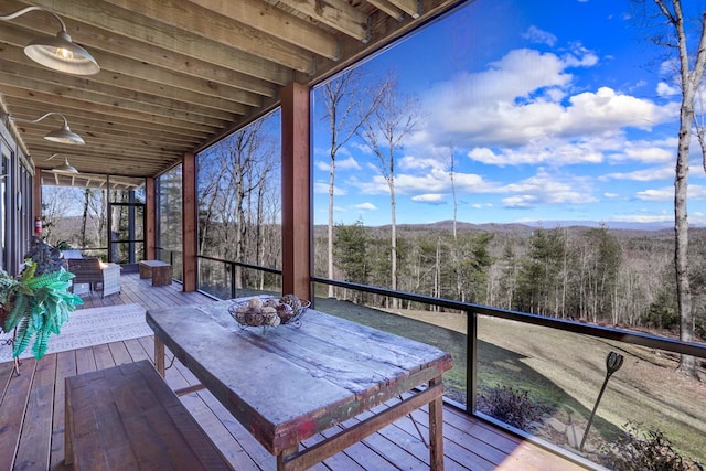 deck with a fire pit and a forest view