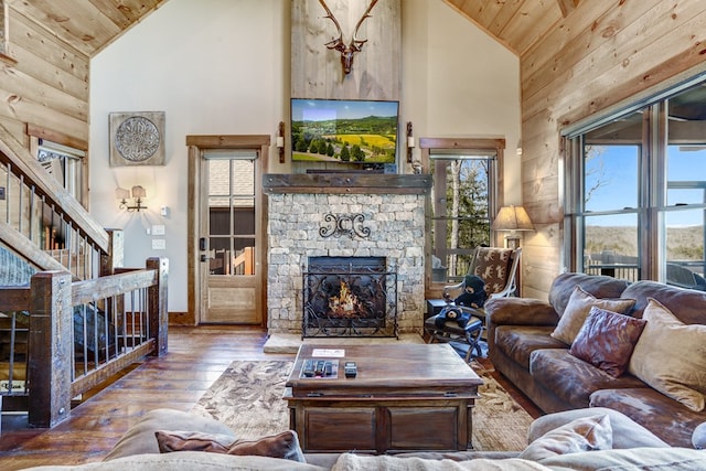 living room with hardwood / wood-style floors, wood ceiling, a fireplace, and high vaulted ceiling