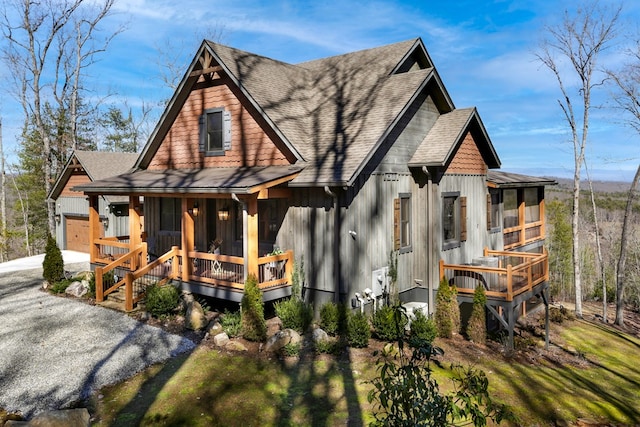 view of front facade with a porch, driveway, and roof with shingles