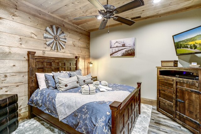 bedroom with visible vents, ceiling fan, wood walls, wood ceiling, and wood finished floors