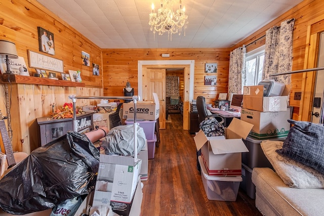 miscellaneous room with dark wood-type flooring, a notable chandelier, and wooden walls