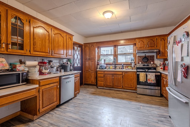 kitchen with sink, stainless steel appliances, and light hardwood / wood-style floors