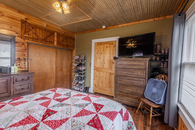 bedroom with dark wood-type flooring, wooden ceiling, wooden walls, and a closet