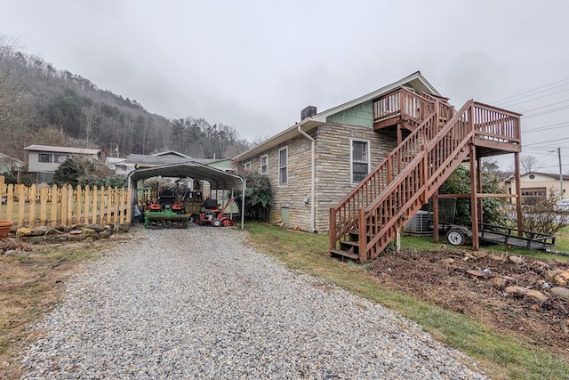 view of side of property with a carport and a deck