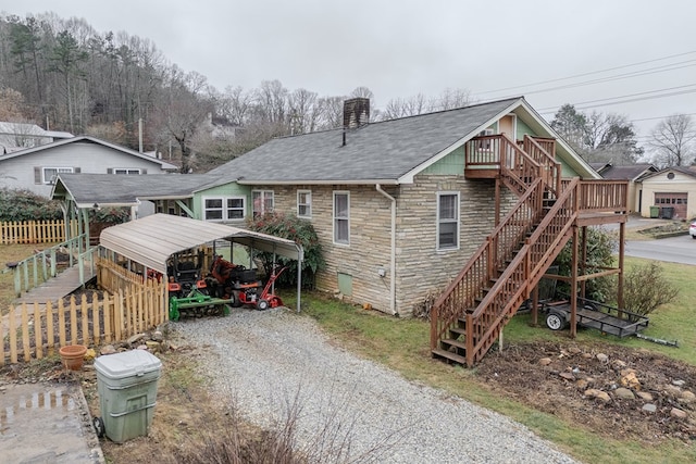 back of property with a carport and a wooden deck