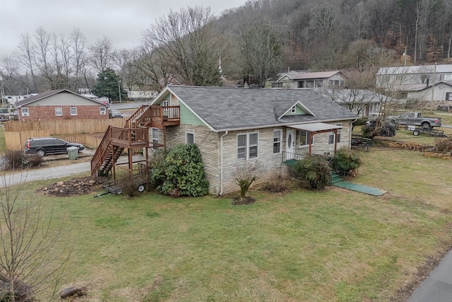 view of front facade featuring a wooden deck and a front lawn