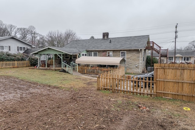 back of house featuring a carport