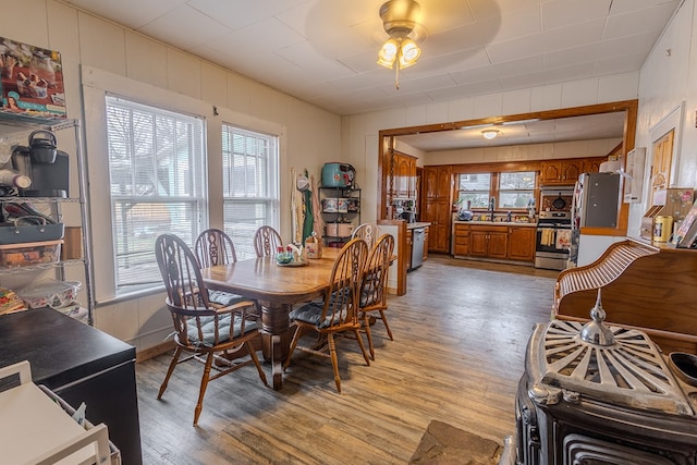 dining space featuring wooden walls and light wood-type flooring