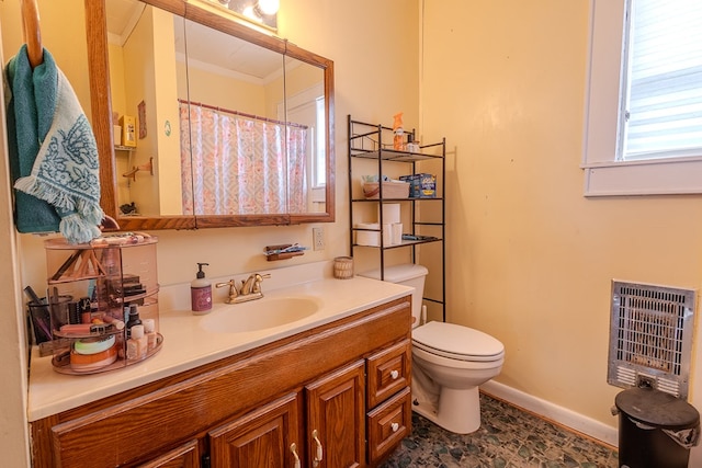 bathroom with vanity, heating unit, and toilet