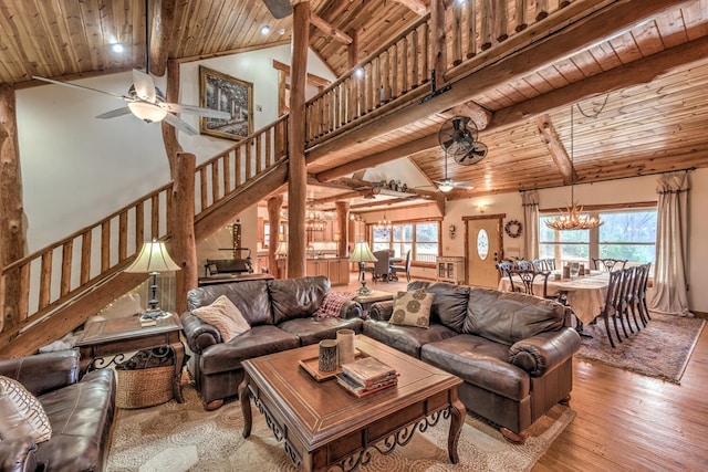 living room featuring high vaulted ceiling, ceiling fan with notable chandelier, beamed ceiling, wooden ceiling, and hardwood / wood-style floors