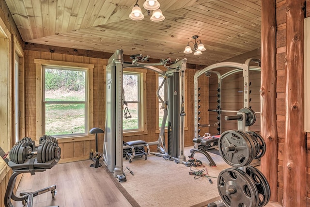 workout room with light wood-type flooring, wood ceiling, vaulted ceiling, and an inviting chandelier