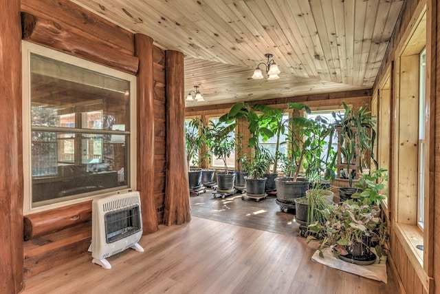 sunroom with wood ceiling, an inviting chandelier, and heating unit