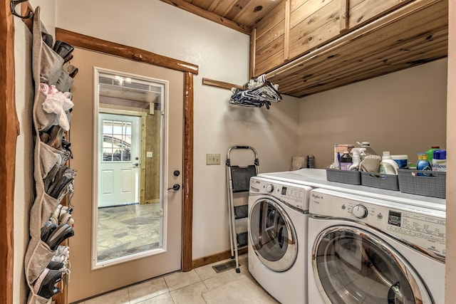 laundry area with wooden ceiling, light tile patterned floors, washer and dryer, and cabinets