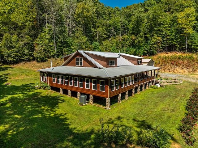 back of house with a yard and central AC