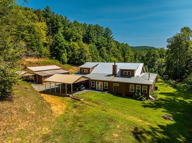 back of property with a lawn and a carport