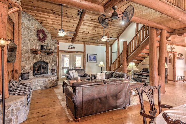 living room with ceiling fan, beamed ceiling, wooden ceiling, a fireplace, and light hardwood / wood-style floors