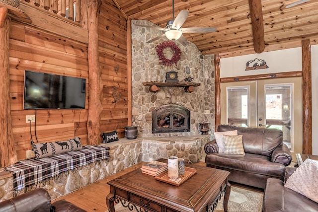 living room with ceiling fan, beam ceiling, high vaulted ceiling, hardwood / wood-style flooring, and a fireplace