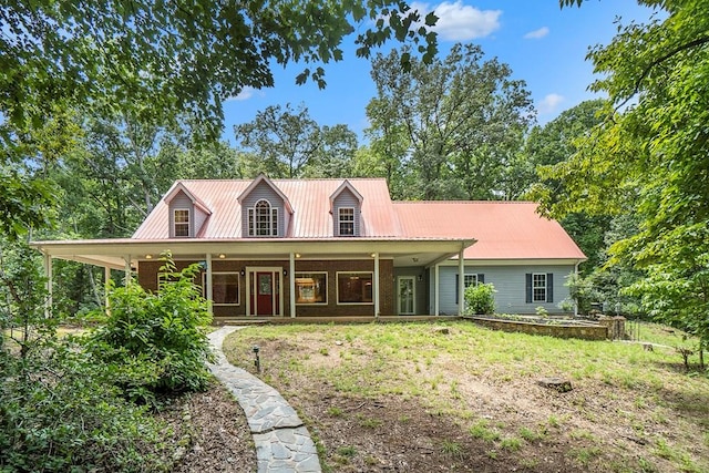 cape cod-style house featuring metal roof, covered porch, and brick siding