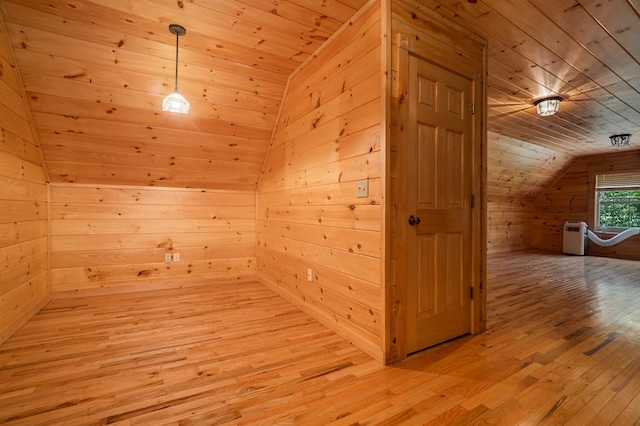 interior space featuring wooden walls, vaulted ceiling, light hardwood / wood-style flooring, and wooden ceiling