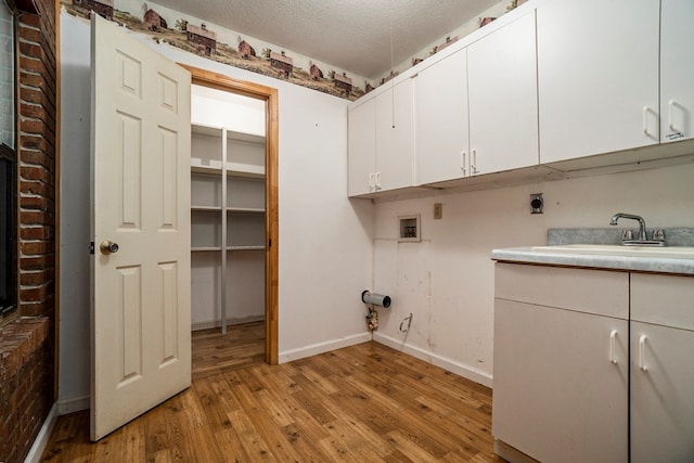 laundry area with sink, cabinets, light hardwood / wood-style floors, hookup for a washing machine, and electric dryer hookup