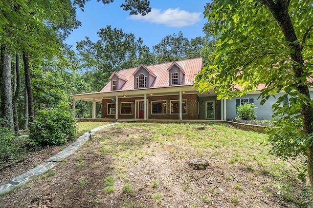 cape cod-style house featuring a front lawn and covered porch