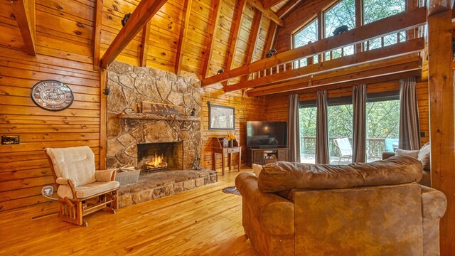 living room featuring hardwood / wood-style floors, a fireplace, wood ceiling, high vaulted ceiling, and beam ceiling