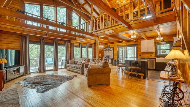 living room featuring wooden ceiling, wooden walls, light hardwood / wood-style flooring, and high vaulted ceiling