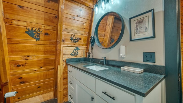 bathroom featuring vanity and wood walls