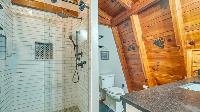 bathroom with vanity, beamed ceiling, toilet, wooden ceiling, and a tile shower