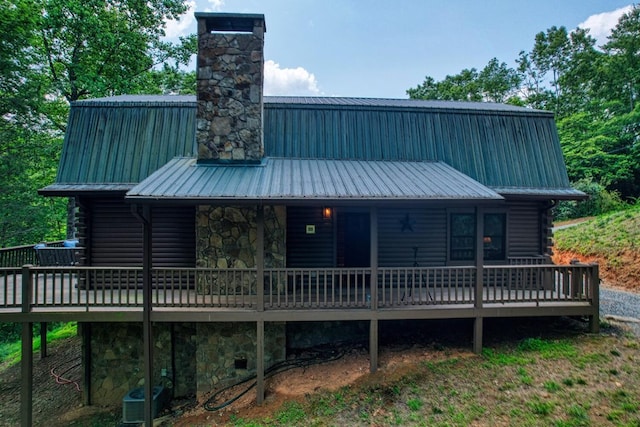 rear view of property with a deck and cooling unit