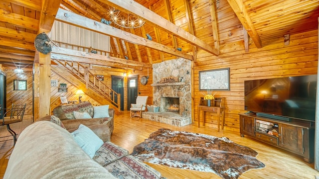 living room with light hardwood / wood-style flooring, beamed ceiling, wooden walls, and wooden ceiling