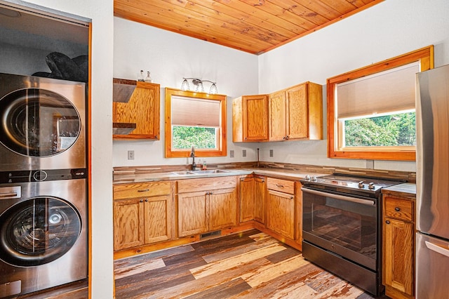 kitchen with stacked washer / dryer, a sink, wood ceiling, electric stove, and freestanding refrigerator