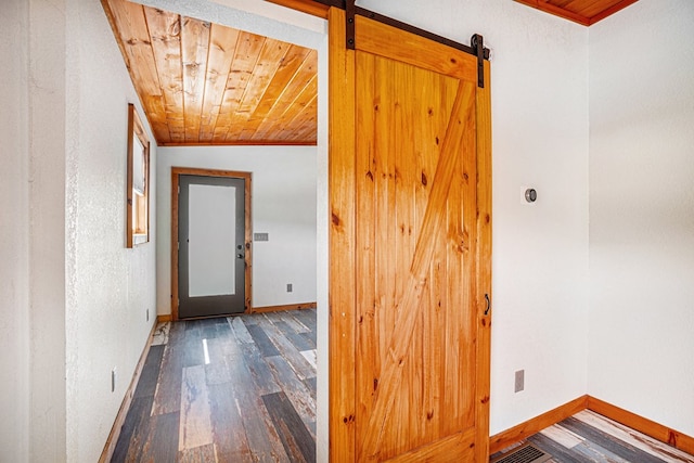 corridor featuring a barn door, dark wood-type flooring, lofted ceiling, and wooden ceiling